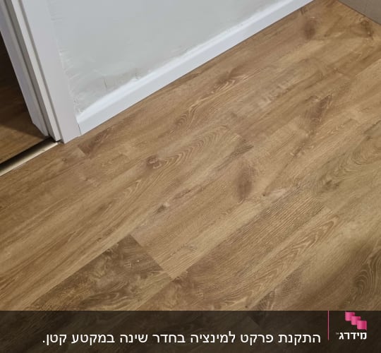 רצפת פרקט עץ חום ליד קיר לבן
